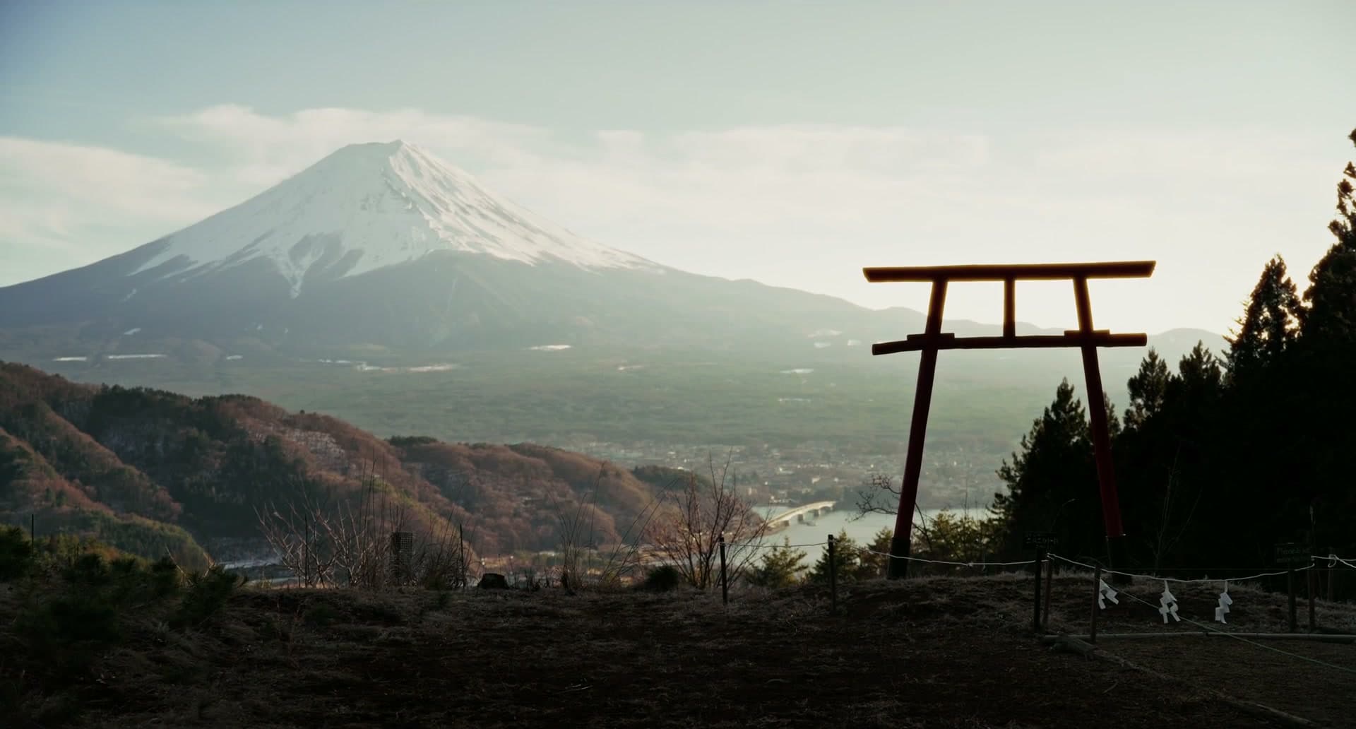 Mount Fuji at dawn, a red torii gate in the foreground